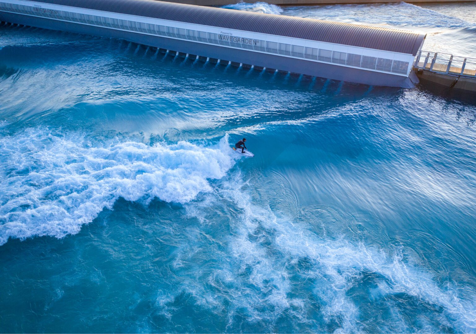 Man surfs in inland surf lake at The Wave in Bristol