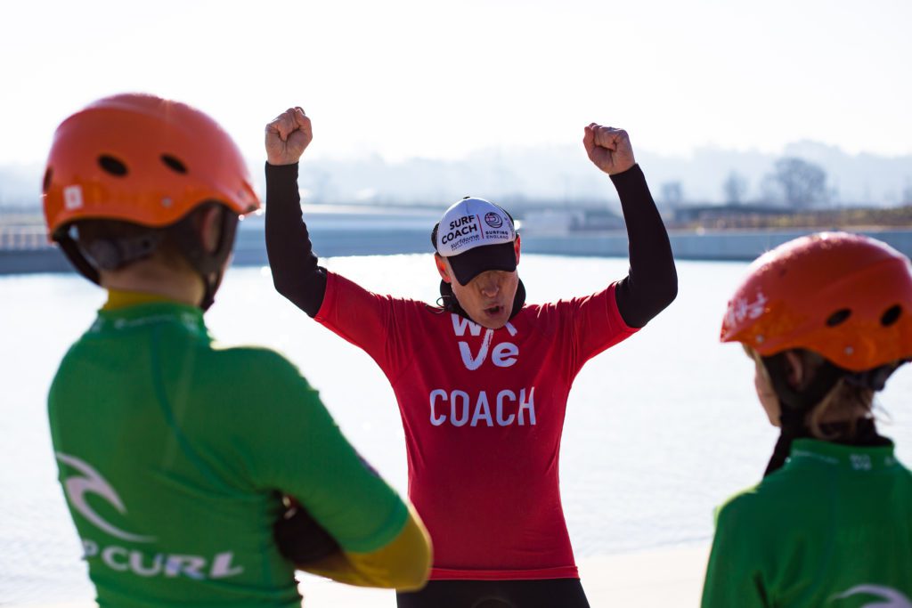 Surf coach teaching two kids at inland surfing lake The Wave in Bristol