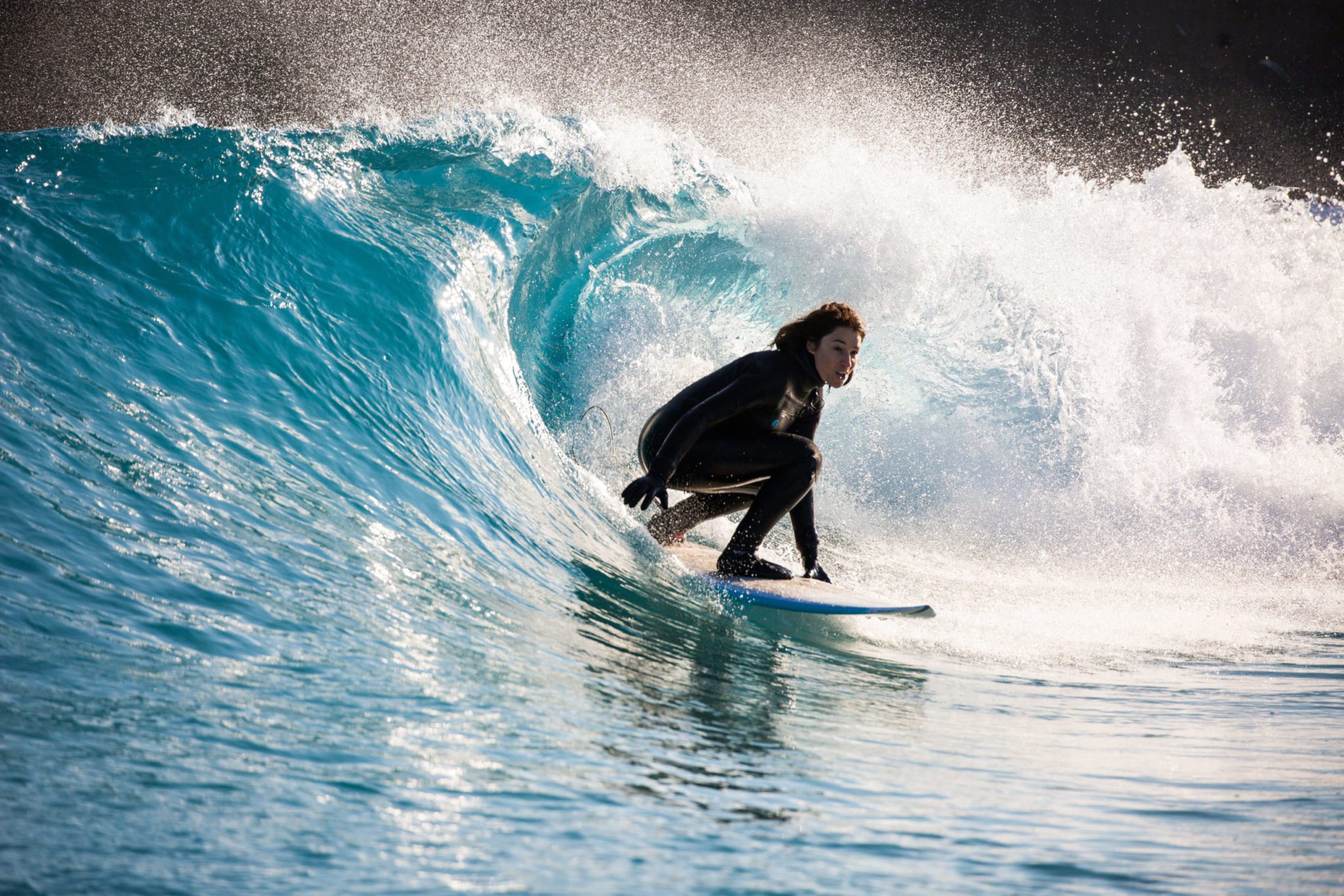 Woman coming out of a barrel at The Wave, surfing inland lake in Bristol
