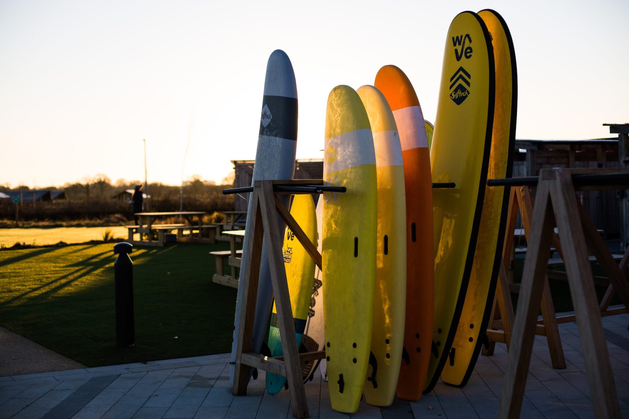 Multi coloured softech surfboards in a surf rack at the Wave inland surfing lake in Bristol