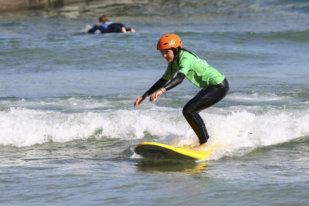 Beginner surfer learning to stand up at the Wave inland surfing lake in Bristol