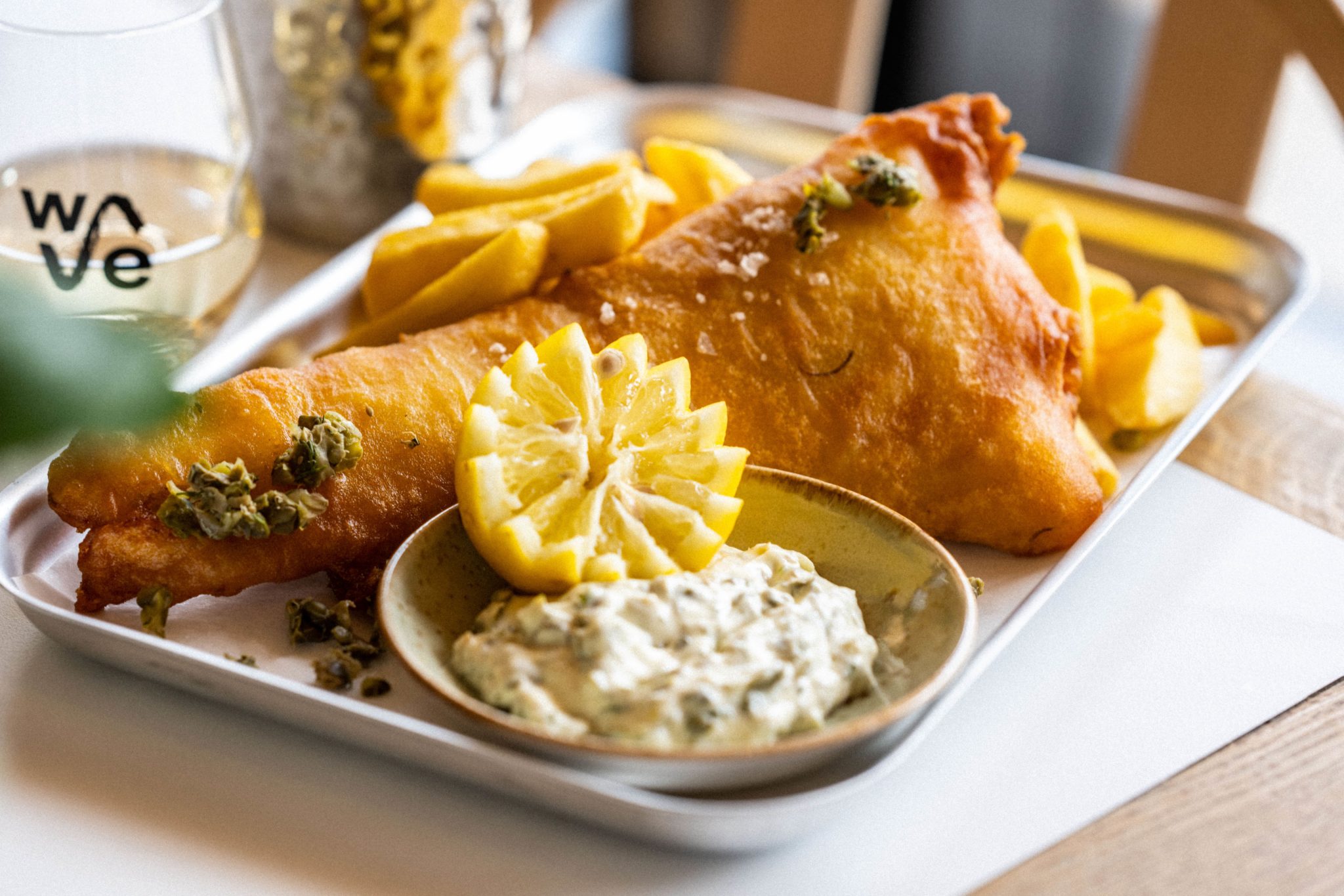 Close-up Cider battered catch of the day, thick cut chips and tartar sauce from The Wave inland surfing lake near Bristol