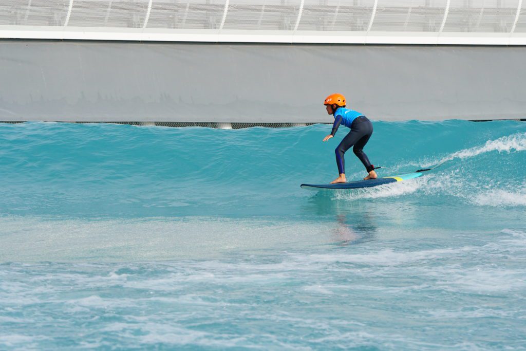 Kid surfing green waves at The Wave in Bristol