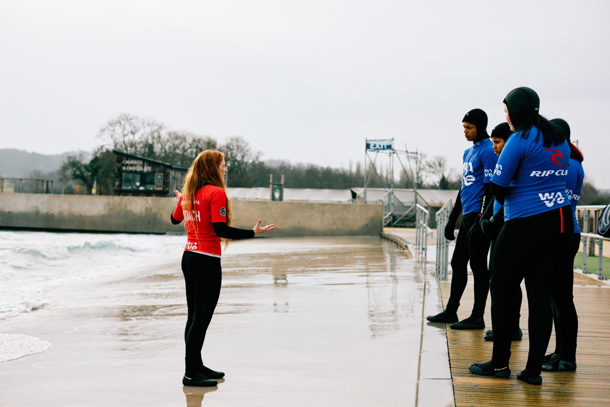 Surf coach teaches group how to surf at The Wave inland surf lake near Bristol