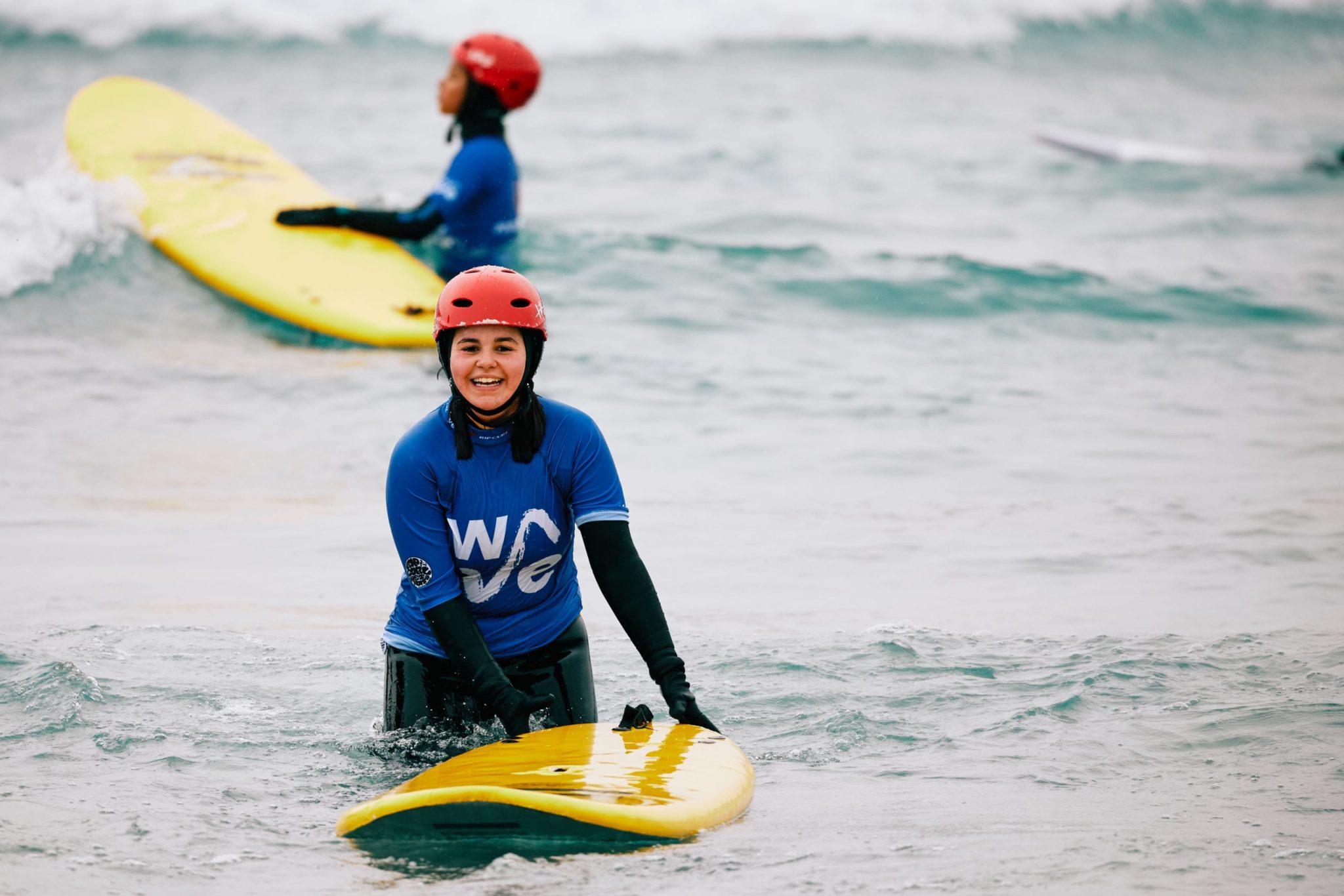 Gril smiles while having a surf lesson at The Wave inland surf lake near Bristol