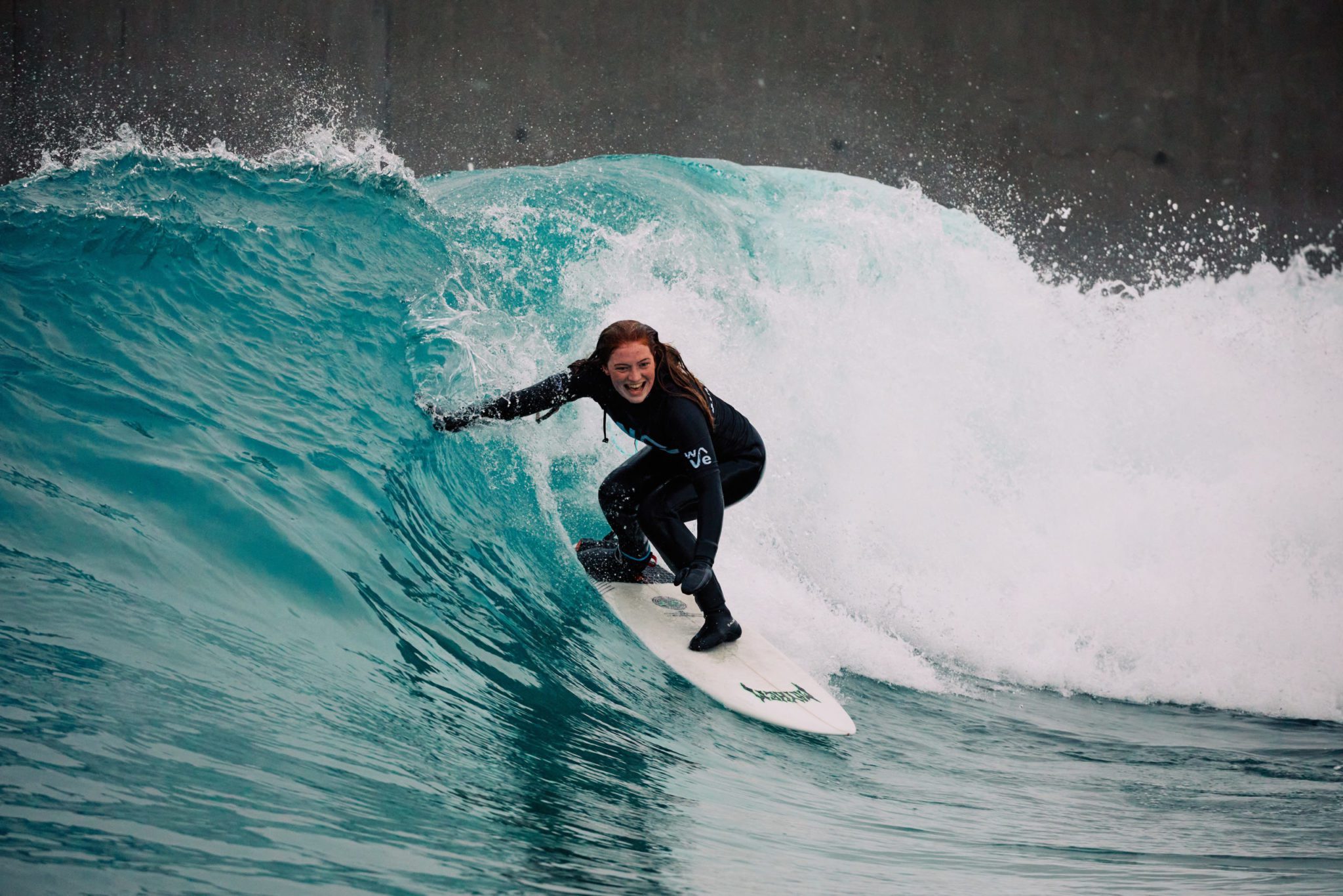 Woman enjoying surfing at The Wave, surfing inland lake in Bristol