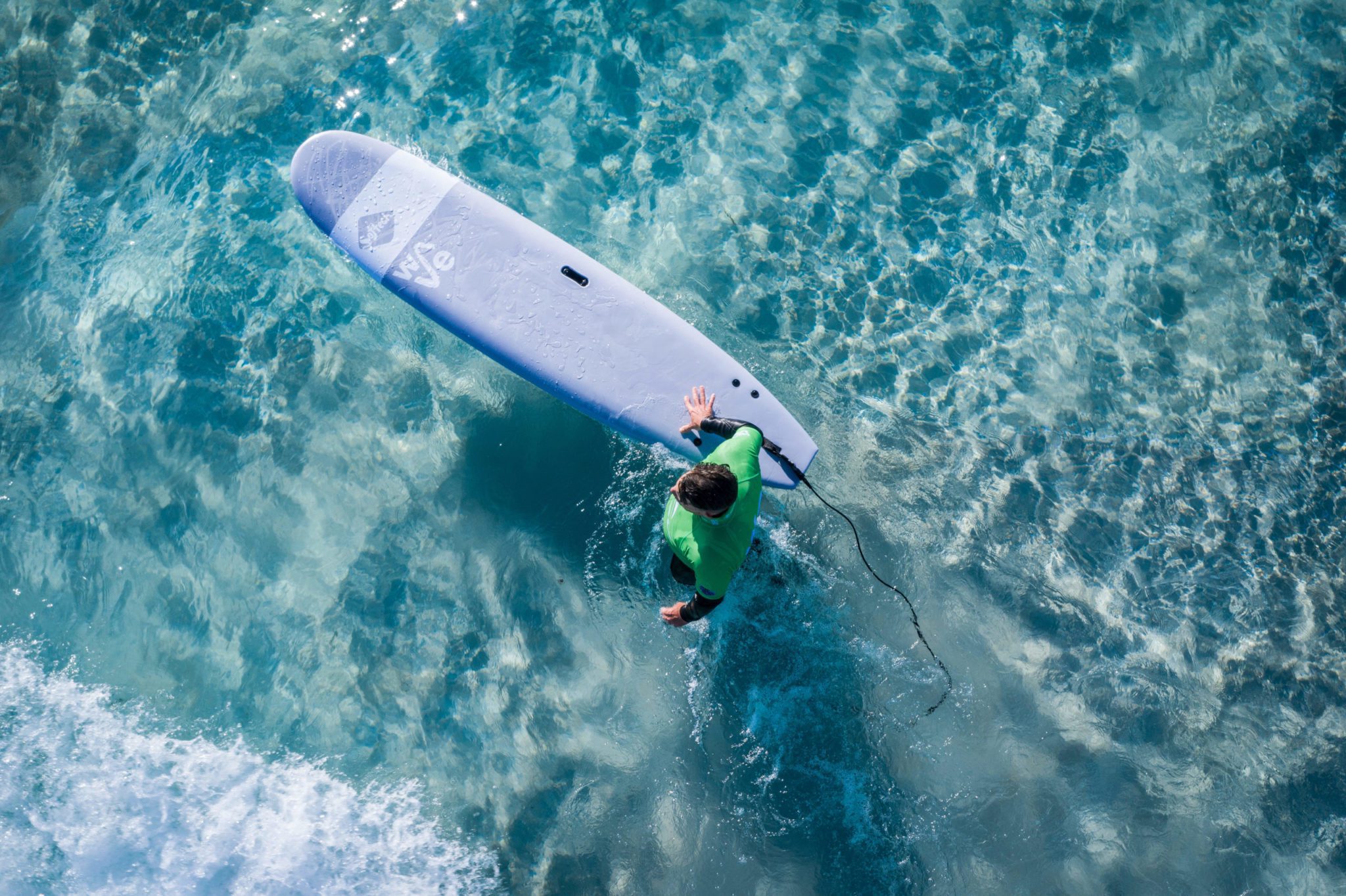 Aerial of a surfer holding a softboard at the inland surfing lake of The Wave in Bristol