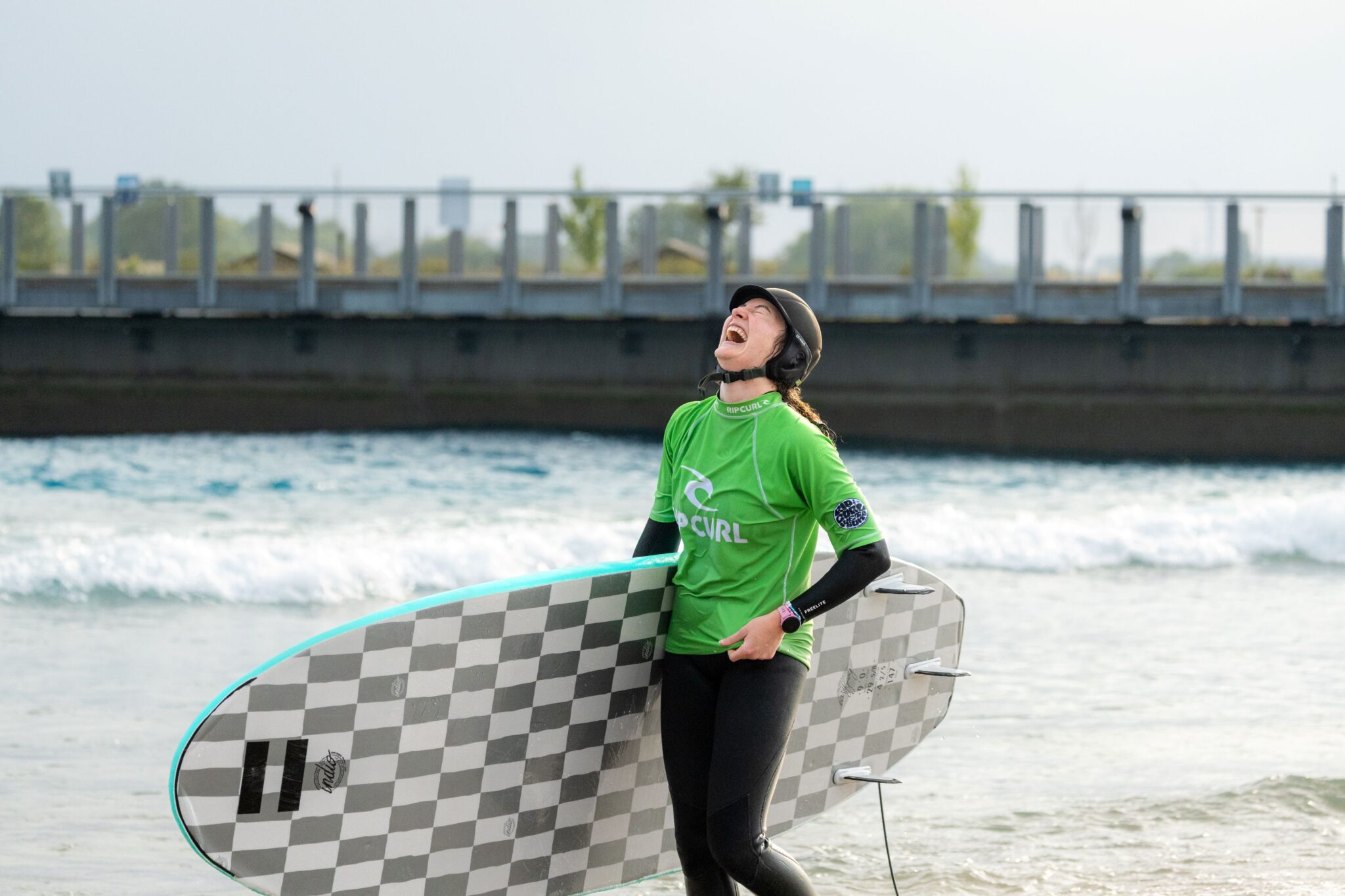 A learner surfer laughing on the shoreline at The Wave Bristol