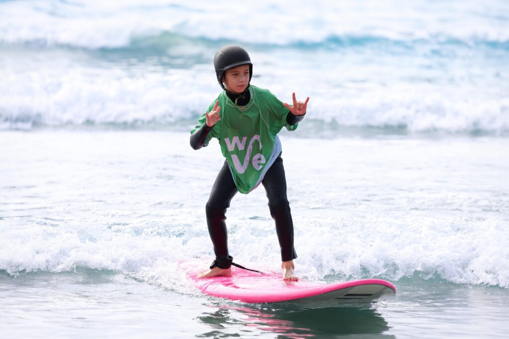 child learns to surf in a little rippers lesson at the wave inland surf lake near bristol
