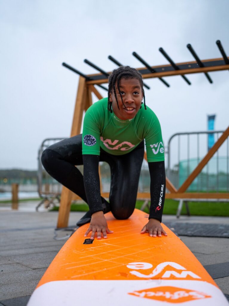 A child practices on a surfboard in a Beginner Lesson at The Wave Bristol