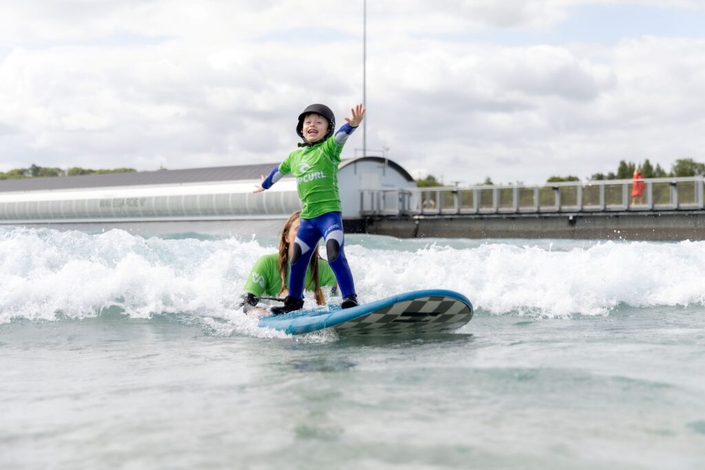 A child learns to surf with his mum in a Little Ripper lesson at The Wave in Bristol