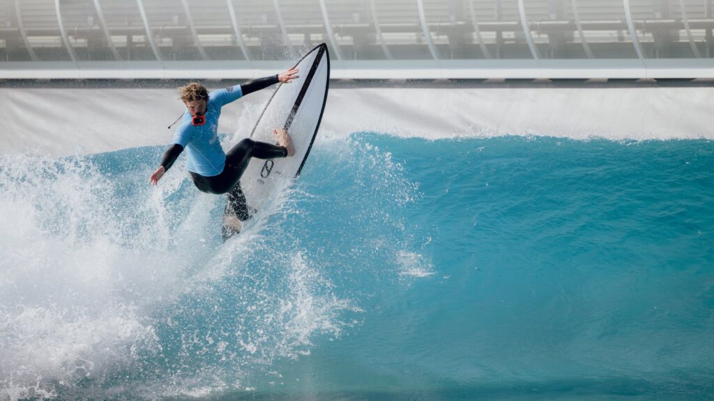 Surfer on big wave doing a turn on surfboard at wave pool in Bristol