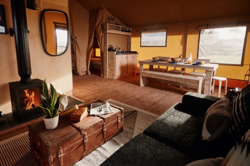 Interior shot of Safari tent with log burner fire and dinner table
