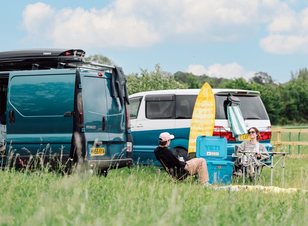 Campers in the Field at the wave with campervans