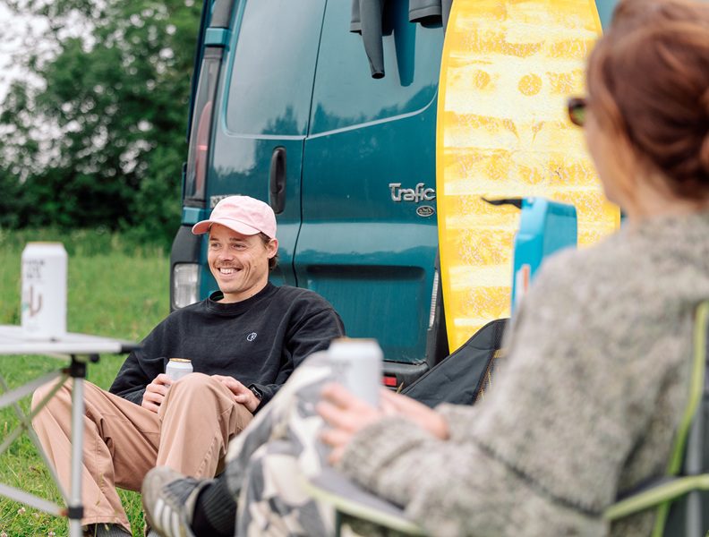 Surfers camping in the Field at the wave with campervans