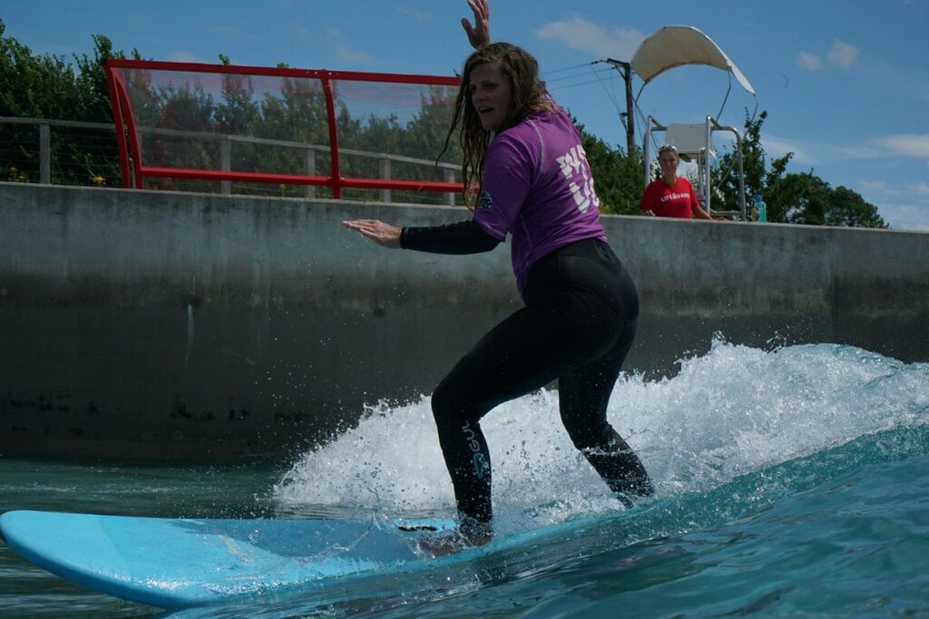 Woman surfing on Sister Session day