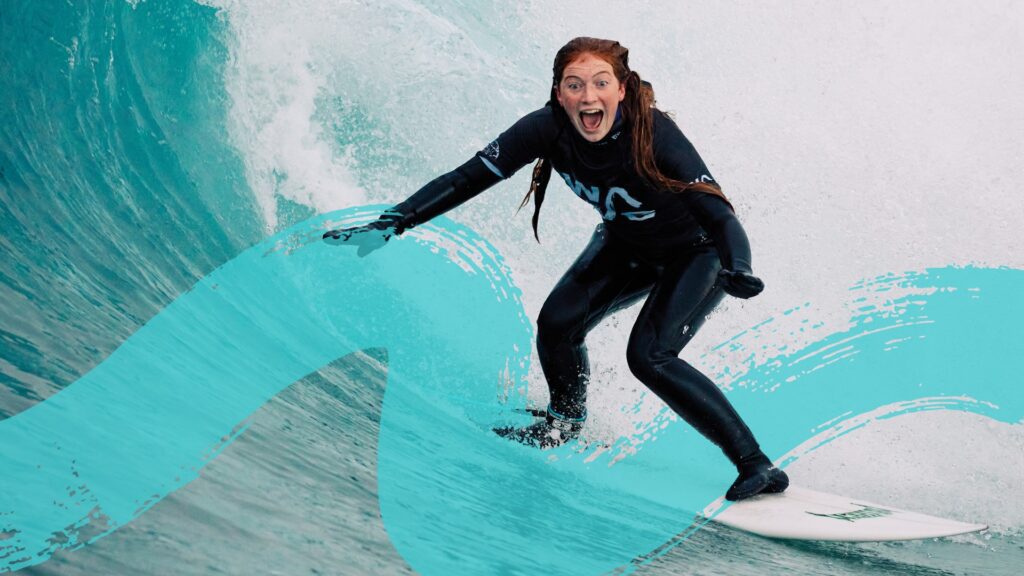Female in winter wetsuit surfing at the Wave