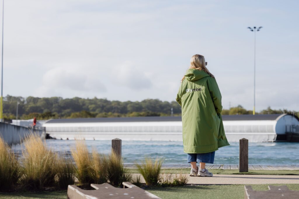 Woman in Dryrobe on the shore at The Wave